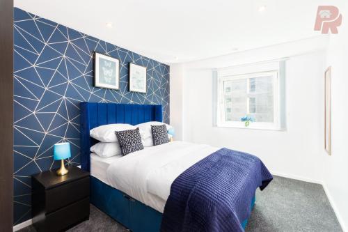 a blue and white bedroom with a bed and a window at Two Bedroom Flat By Emporium Property Management Short Lets & Serviced Accommodation Birmingham With Balcony & Close To Central Massplaza in Birmingham