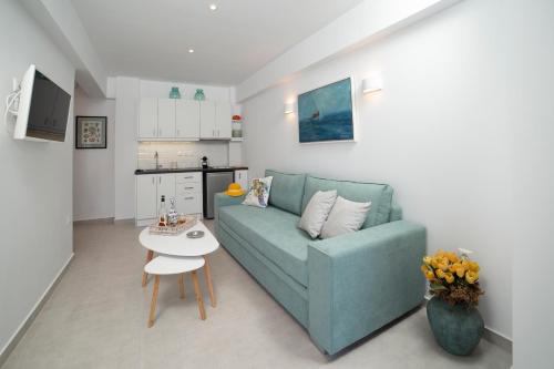 a living room with a blue couch and a table at Korina's Suites in Andros