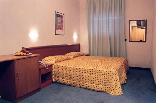 a hotel room with a bedroom with a bed and a table at Hotel Italia in Carmagnola