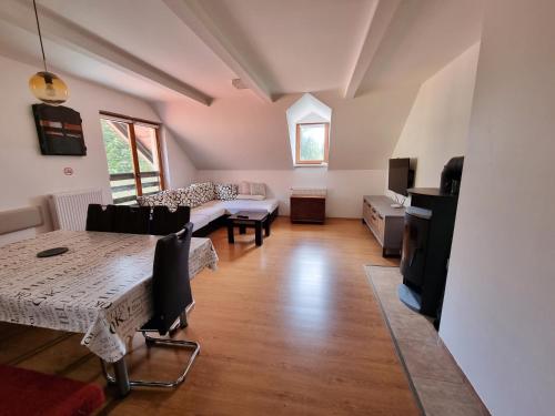 ein großes Wohnzimmer mit einem Tisch und einem Sofa in der Unterkunft Apartma Jakob Rogla in Vitanje