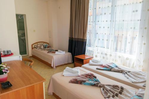 ソゾポルにあるGuest house Eosのベッド2台と窓が備わるホテルルームです。