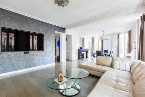 un salon avec un canapé blanc et une table dans l'établissement Appartement exceptionnel avec terrasse en plein coeur de Paris - Welkeys, à Paris