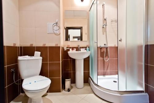 y baño con aseo, lavabo y ducha. en Saint George Palace Hotel, en Sveti Vlas