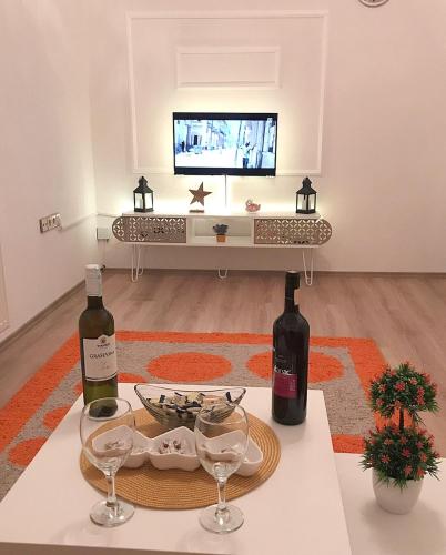 a living room with two bottles of wine on a table at Apartman Dunja II in Prijedor