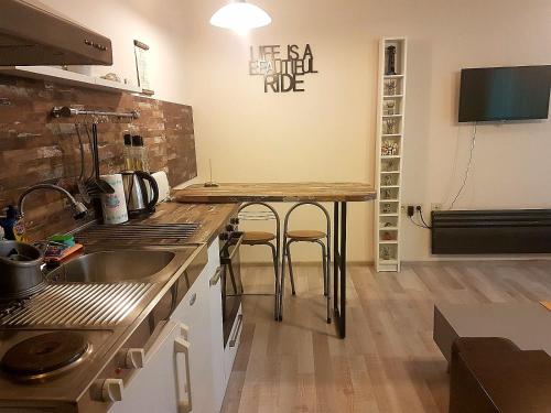 a kitchen with a counter and a table with stools at Aheloy Apartments in Aheloy