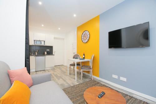 un salon avec un canapé et une table dans l'établissement Les Poissons, T2 hypercentre chic et cosy, Wifi par SOVALFI, à Saint-Étienne