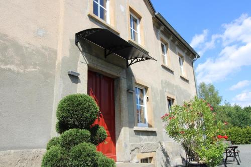 a building with a red door and a red window at Ferienwohnung in herrlicher Teichlandschaft in Caminau