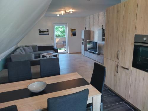 eine Küche und ein Wohnzimmer mit einem Tisch und einer Couch in der Unterkunft Ferienwohnung "Schwalbennest" in Motzen