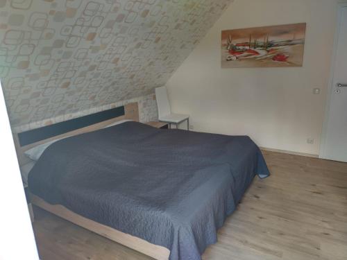 1 dormitorio con 1 cama con manta azul en Ferienwohnung "Schwalbennest", en Motzen