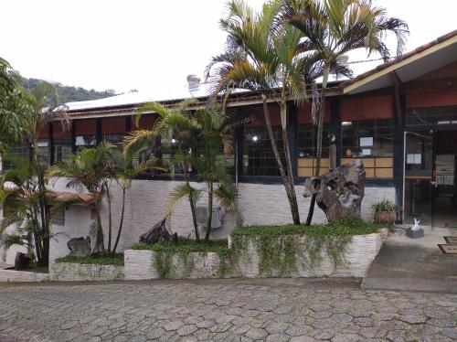 un edificio con palmeras delante en Pousada Juriti - Eco Hotel, en São Roque