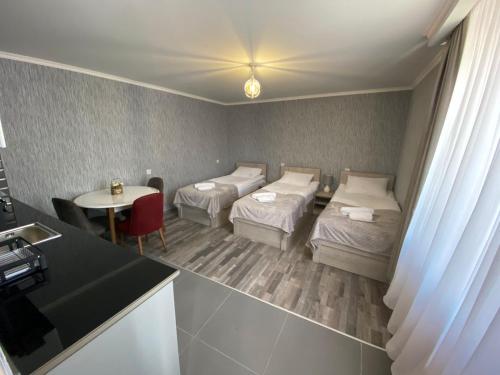 a room with two beds and a table with a table at Apartments Gio-Nika in Stepantsminda