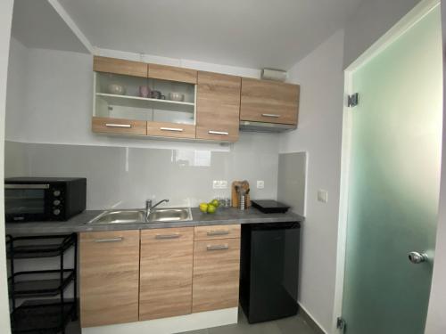 a kitchen with wooden cabinets and a sink at Tiny Little House in Athens
