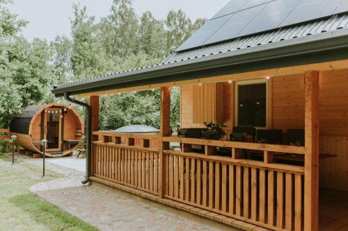 a cabin with a solar roof on a deck at Duch Huszczy w środku sosnowego lasu in Łomazy