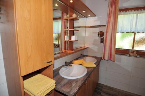 a bathroom with two sinks and a mirror at Ferienwohnung Maria Erlsbacher in Sankt Veit in Defereggen