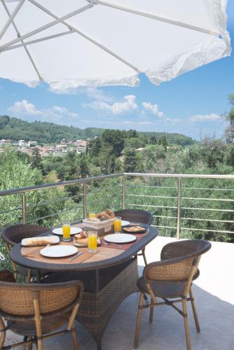 a table with food and drinks on a balcony at Olea Stone House near the sea in Nótos
