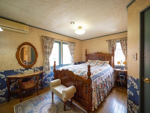 een slaapkamer met een bed, een stoel en een spiegel bij Montania Nasu Grande - Vacation STAY 59678v in Shiozawa