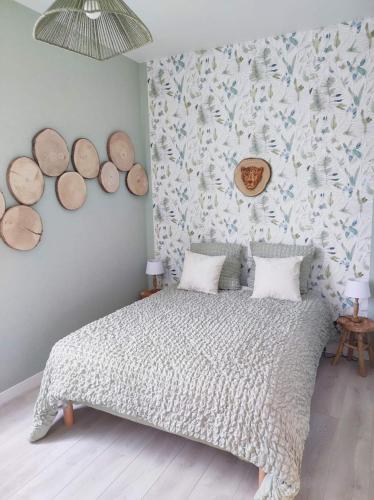 - une chambre avec un lit et un mur avec des bûches dans l'établissement Zoologîte, à Saint-Aignan