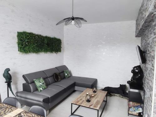 a living room with a couch and a table at Zoologîte in Saint-Aignan