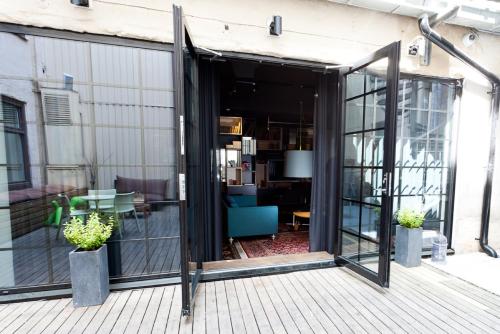 an open glass door on a patio with plants at Hotel Flora in Gothenburg