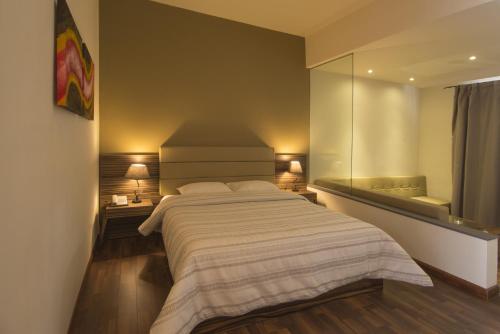 a bedroom with a large bed and a large mirror at Casa Florida Hotel & Spa in Pereybere
