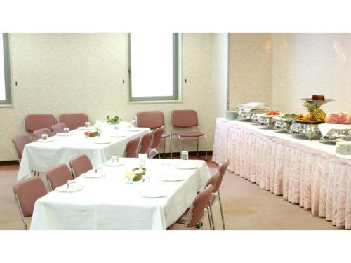 une salle à manger avec des tables, des chaises et un tissu de table blanc dans l'établissement Pulsesin in Kyoto - Vacation STAY 73544v, à Kyoto