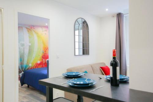 une salle à manger avec une table et une bouteille de vin dans l'établissement La Montgolfière, T2 hypercentre chic et cosy, Wifi par SOVALFI, à Saint-Étienne