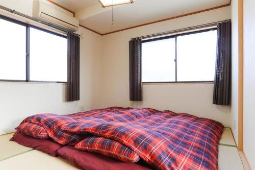 a bed in a room with three windows at kyoto demachiyanagi - Vacation STAY 76317v in Kyoto