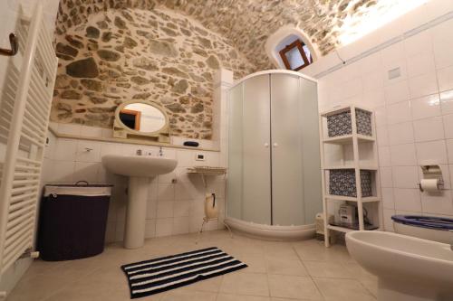 y baño con lavabo y ducha. en Appartamento in borgata storica, en Boissano