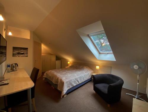 a bedroom with a bed and a desk and a window at Vila Claudia in Palanga