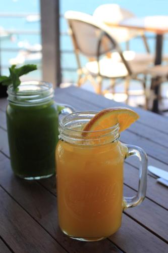 two mason jars of orange juice on a wooden table at Seven Crown La Paz Malecon in La Paz