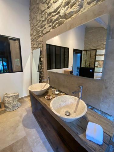 une salle de bain avec deux lavabos et un grand miroir dans l'établissement Mas Gabriel - St Rémy de Provence, à Saint-Rémy-de-Provence