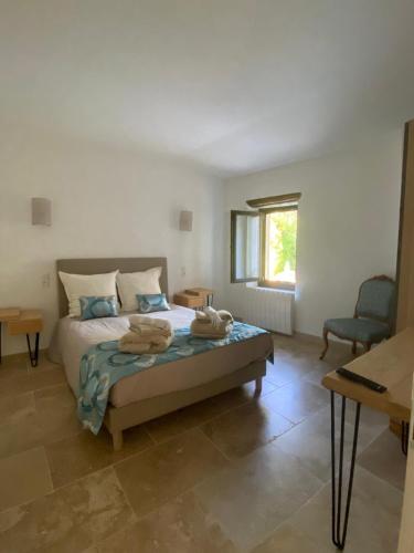 une chambre avec un lit avec deux serviettes dessus dans l'établissement Mas Gabriel - St Rémy de Provence, à Saint-Rémy-de-Provence