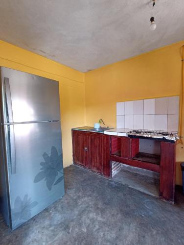 a kitchen with a refrigerator and a yellow wall at Casa De Descanso Cuautla Morelos in Cuautla Morelos