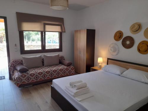 ein Schlafzimmer mit einem Bett und einem Sofa in der Unterkunft MAD'S Villas in Néa Péramos