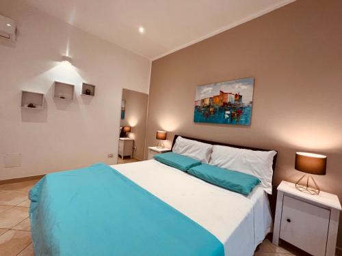a bedroom with a large bed with blue pillows at Casa dei fiori in Carovigno