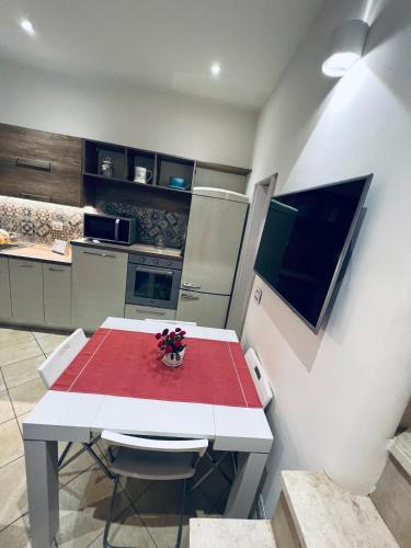 a kitchen with a white table with a red table cloth at Casa dei fiori in Carovigno