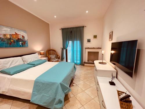 - une chambre avec un lit et une télévision à écran plat dans l'établissement Casa dei fiori, à Carovigno