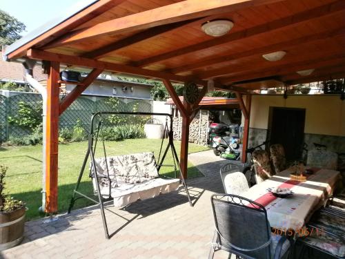 a patio with a wooden pergola with a swing at Flamingo Apartman in Sopron