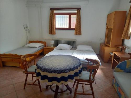Habitación con 2 camas, mesa y sillas en Flamingo Apartman en Sopron