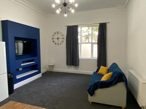 sala de estar con sofá azul y TV en Lovely 1 bed ground floor flat in Leamington Spa, en Leamington Spa