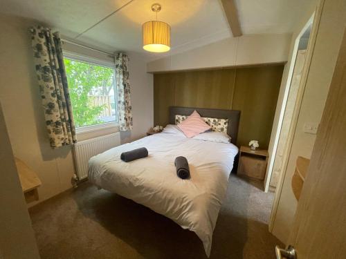 a bedroom with a bed with a pillow and a window at Two Bedroom Caravan at Lilliarsedge in Jedburgh
