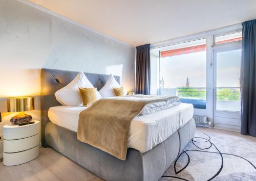ein Schlafzimmer mit einem großen Bett und einem großen Fenster in der Unterkunft GelsenDesign III - Netflix I Balkon I Zentral in Gelsenkirchen