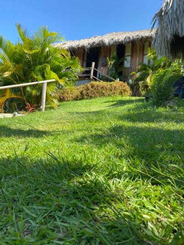 a grass yard with a house in the background at Casa Algana in El Limón