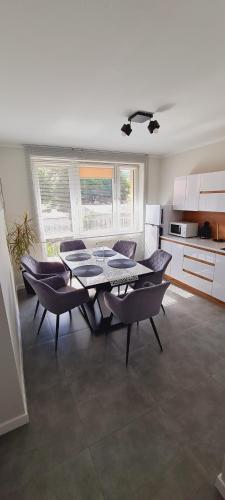 a kitchen with a table and chairs in a room at Apartamenty Diamond na Sportowej in Tylicz