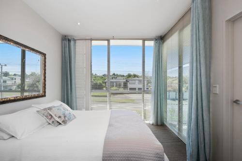 a bedroom with a bed and a large window at Marinaside Villa - Taupo Holiday Apartment in Taupo