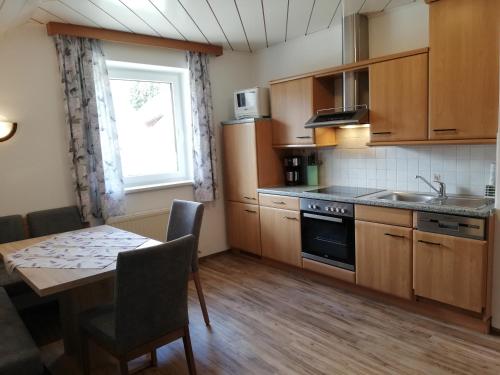 a kitchen with wooden cabinets and a table and a window at Ferienwohnung Marina in Mariapfarr