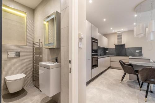 ロンドンにあるModern&Luxurios 1 Bed Apartment-Prime Location.のキッチン(トイレ、シンク、テーブル付)