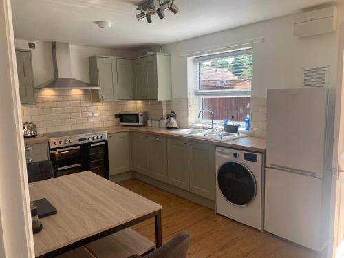 a kitchen with white appliances and a wooden table at Old Street Terrace in Ludlow
