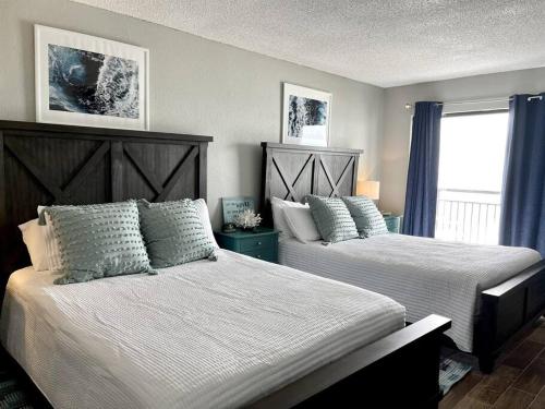 1 dormitorio con 2 camas y ventana en *HUGE OCEANFRONT BALCONY*Queen Beds*TONS of Amenities*L53, en Myrtle Beach