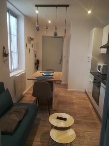 un salon avec un canapé bleu et une table dans l'établissement Appartement calme, à Saint-Maixent-lʼÉcole